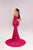 Woman wearing a pink evening gown with a long train on a light gray background