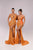 Two women wearing orange evening gowns on a plain background