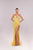 Woman wearing a yellow evening gown with a high slit on a light gray background